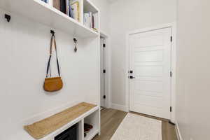 Mudroom with light wood finished floors and baseboards