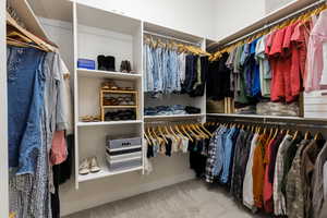 Walk in closet featuring light colored carpet