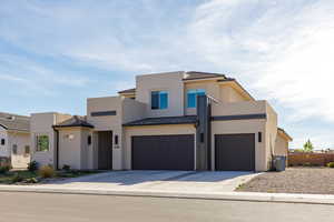 Modern home with driveway, a standing seam roof, and a garage