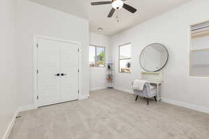Sitting room featuring light colored carpet and ceiling fan