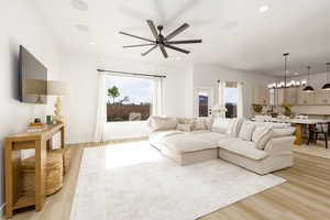 Living room with a ceiling fan, light wood-type flooring, and recessed lighting