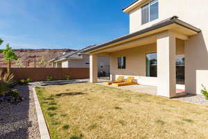 Rear view of house with stucco siding, a patio, and a fenced backyard