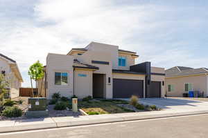 Contemporary house with driveway, stucco siding, and an attached garage