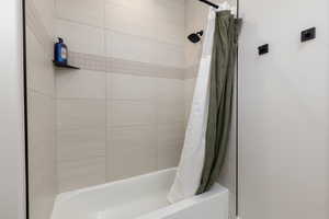 Bathroom featuring shower / bathtub combination with curtain