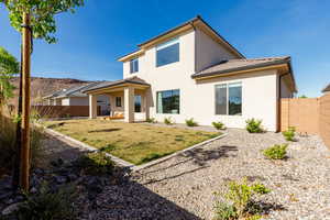 Back of property featuring a fenced backyard, a patio, stucco siding, and a tile roof