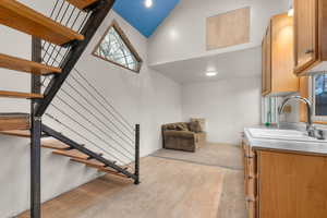 Stairs featuring a high ceiling and wood finished floors