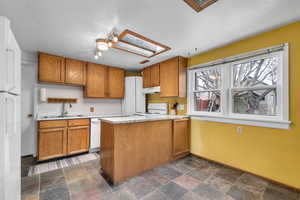 Kitchen featuring light countertops, stone finish floors, and wood finish cabinets