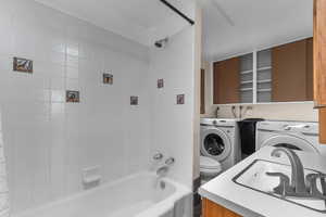 Full bathroom featuring separate washer and dryer, shower / bathtub combination, and vanity
