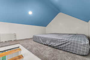 Carpeted bedroom featuring radiator heating unit