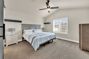 Bedroom with light colored carpet, vaulted ceiling, and a ceiling fan