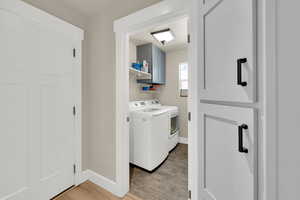 Laundry room featuring light wood finished floors and washing machine and dryer