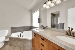 Bathroom featuring double vanity, a garden tub, and a stall shower