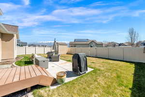 Fenced backyard featuring a patio area, a shed, a deck with mountain view, and a residential view