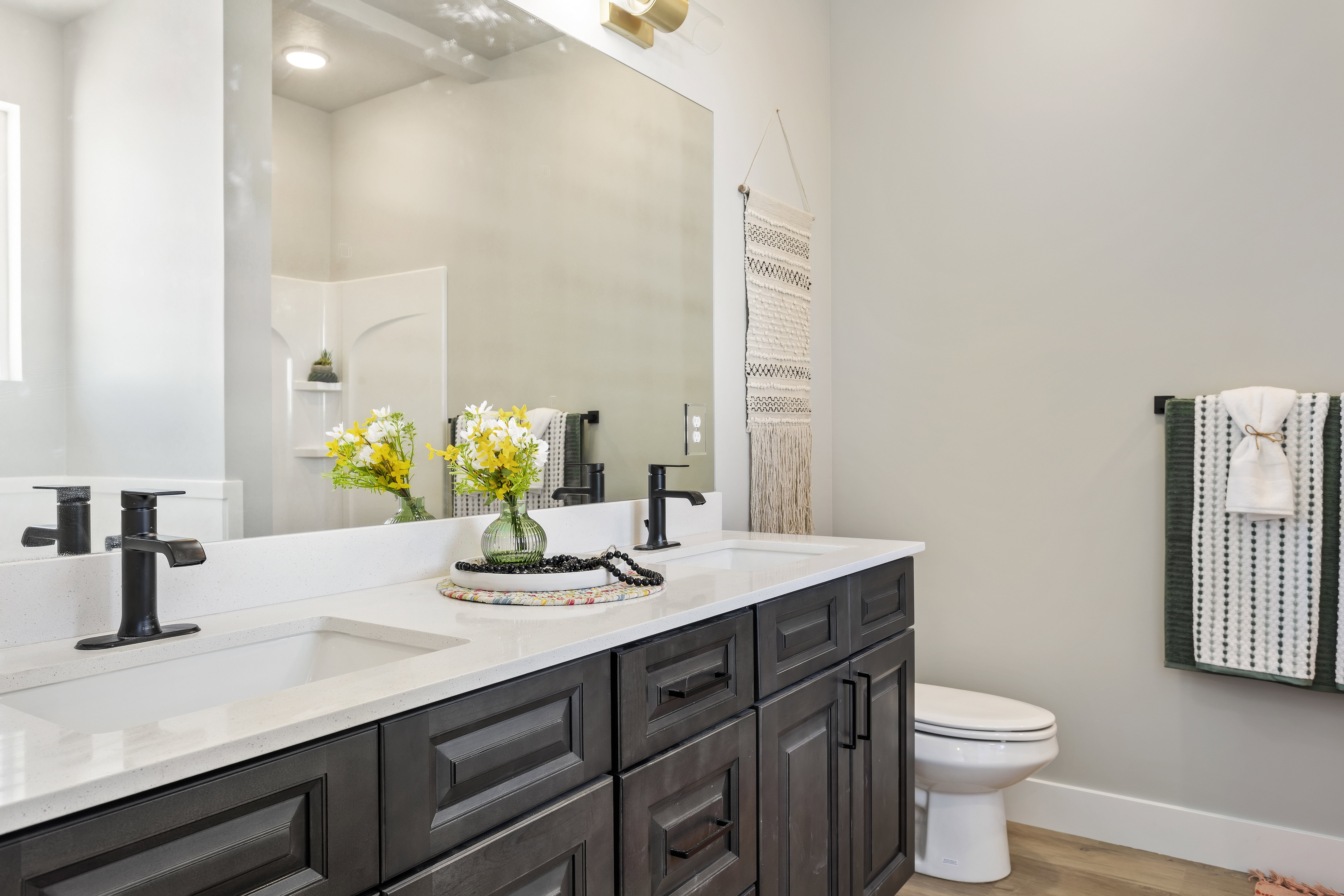 Bathroom with double vanity and light wood-type flooring