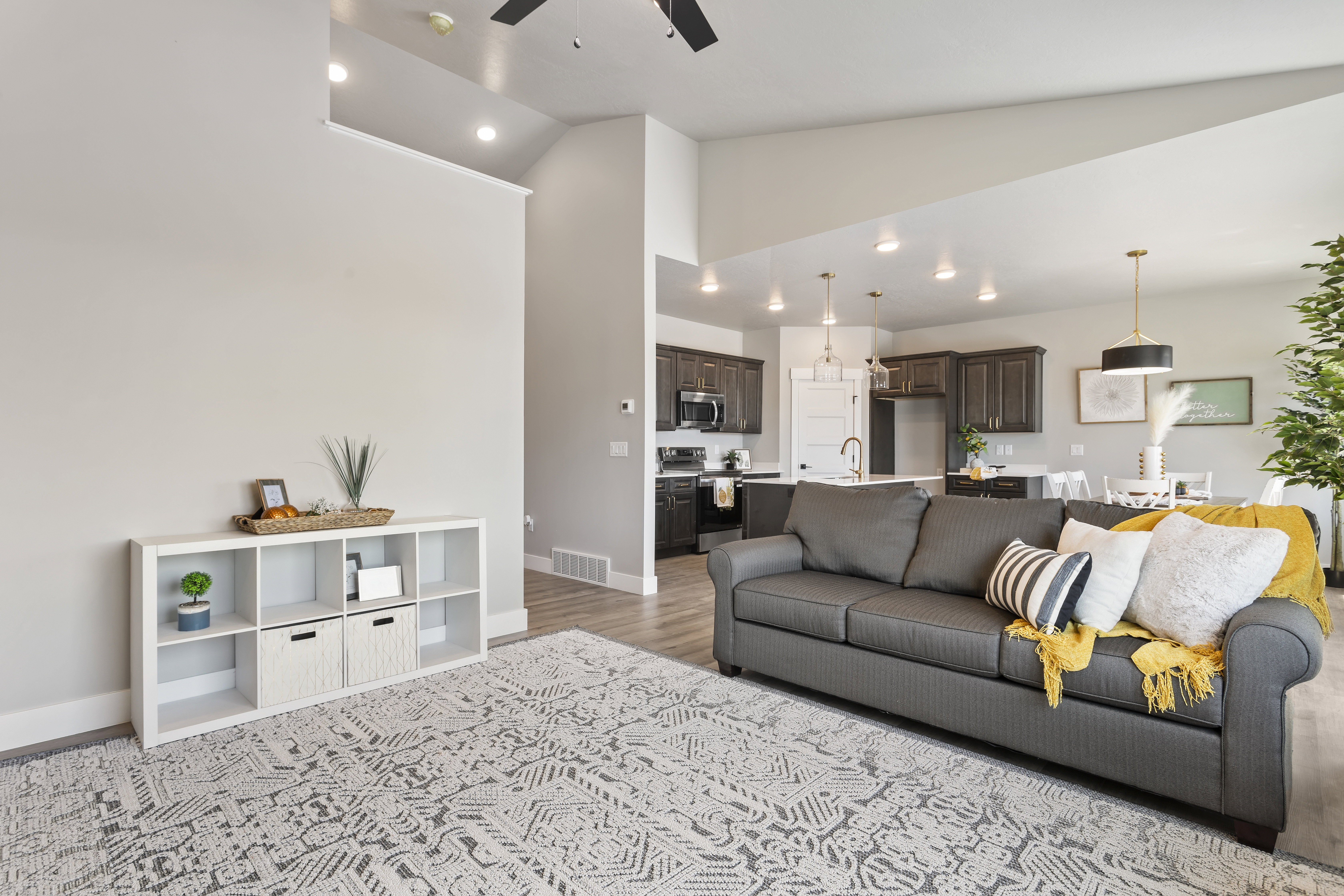 Living room featuring ceiling fan, vaulted ceiling, light wood finished floors, and recessed lighting