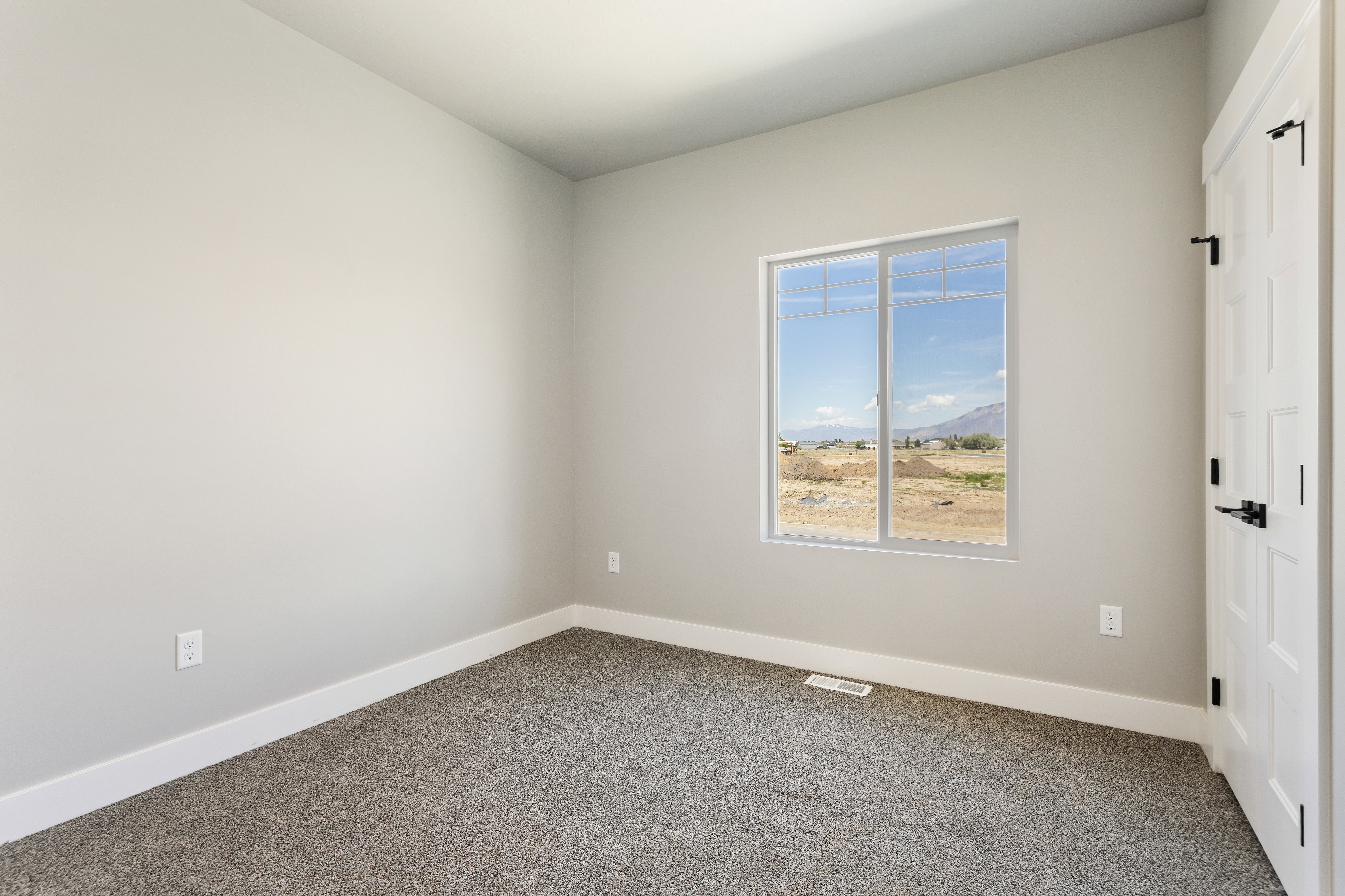 Unfurnished room featuring a mountain view and carpet