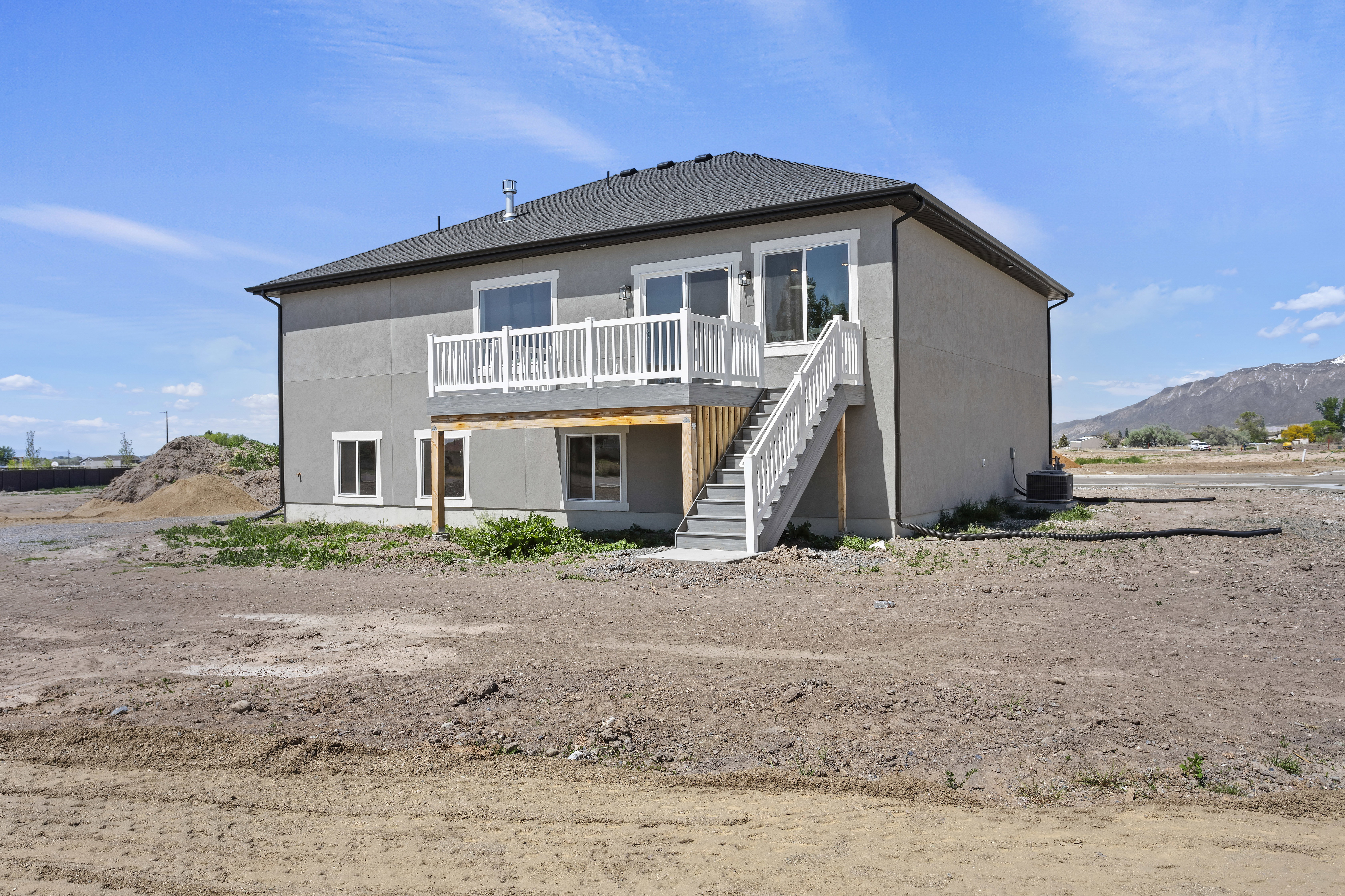 Back of house with a deck with mountain view and stucco siding