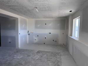 Laundry room with a textured ceiling and hookup for a gas dryer