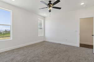 Unfurnished room featuring dark carpet, a ceiling fan, and recessed lighting
