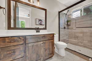 Bathroom featuring plenty of natural light, vanity, and a shower stall
