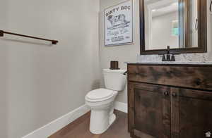 Half bath featuring vanity and dark wood-style flooring