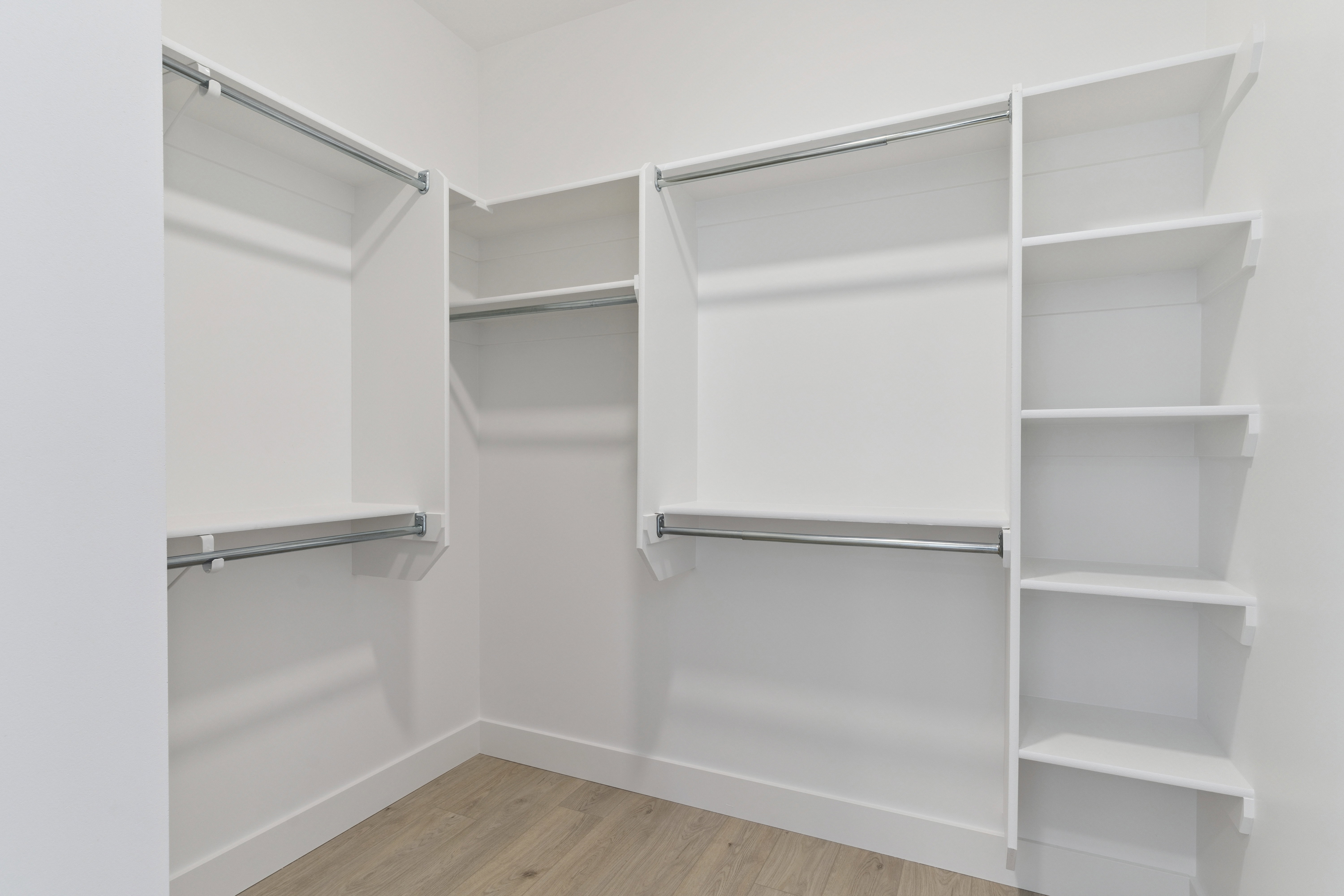 Walk in closet with light wood-type flooring