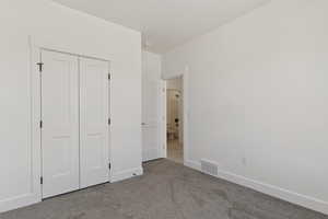 Unfurnished bedroom with carpet and a closet