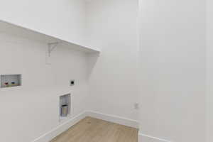 Laundry room with light wood-type flooring, hookup for a washing machine, and hookup for an electric dryer