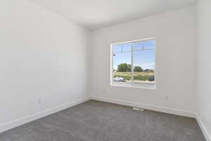 Carpeted empty room featuring baseboards