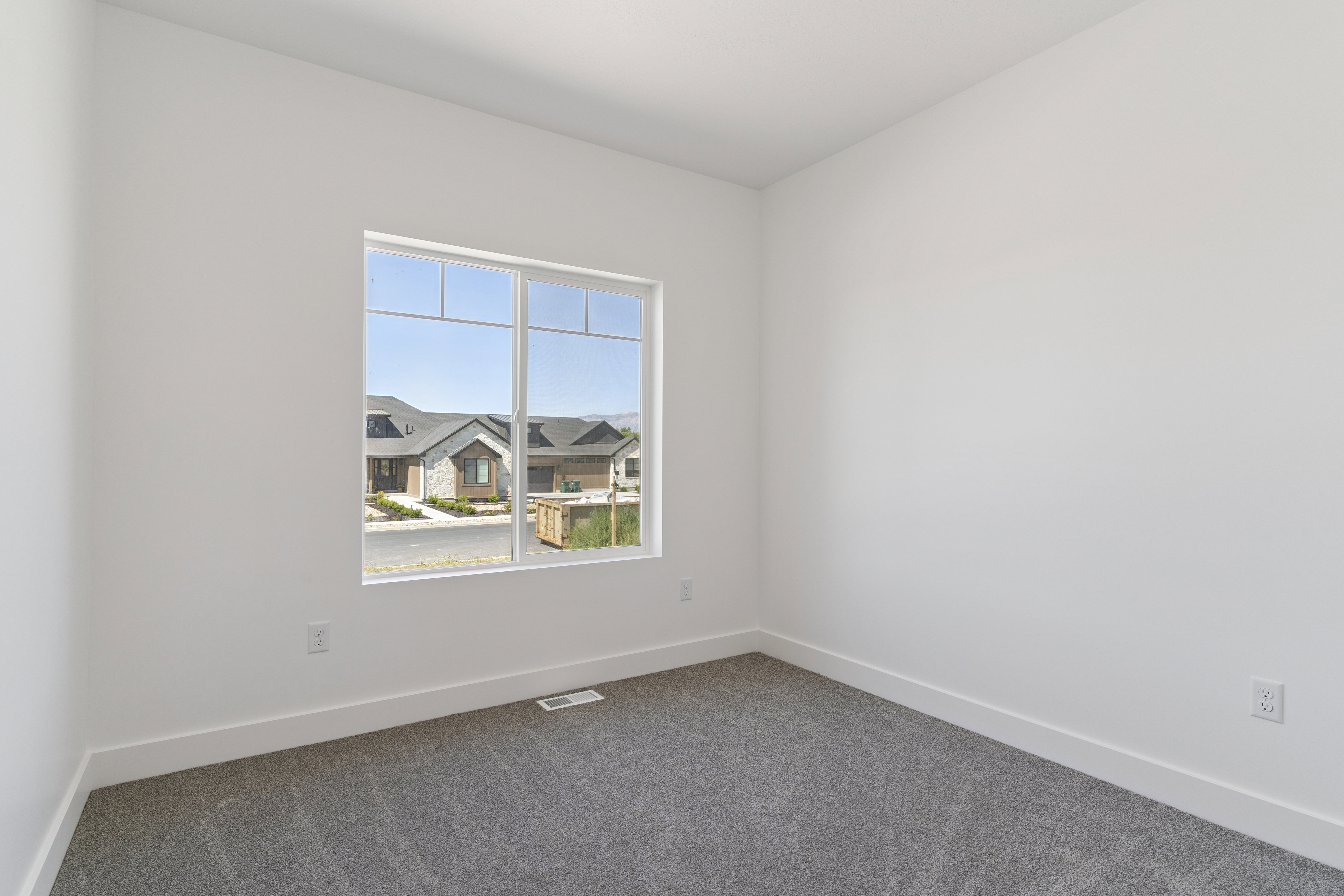 Empty room featuring baseboards and dark carpet