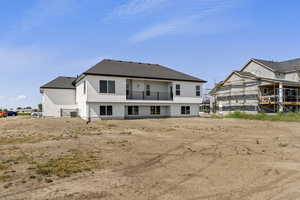 Rear view of property featuring a balcony, a shingled roof, and stucco siding