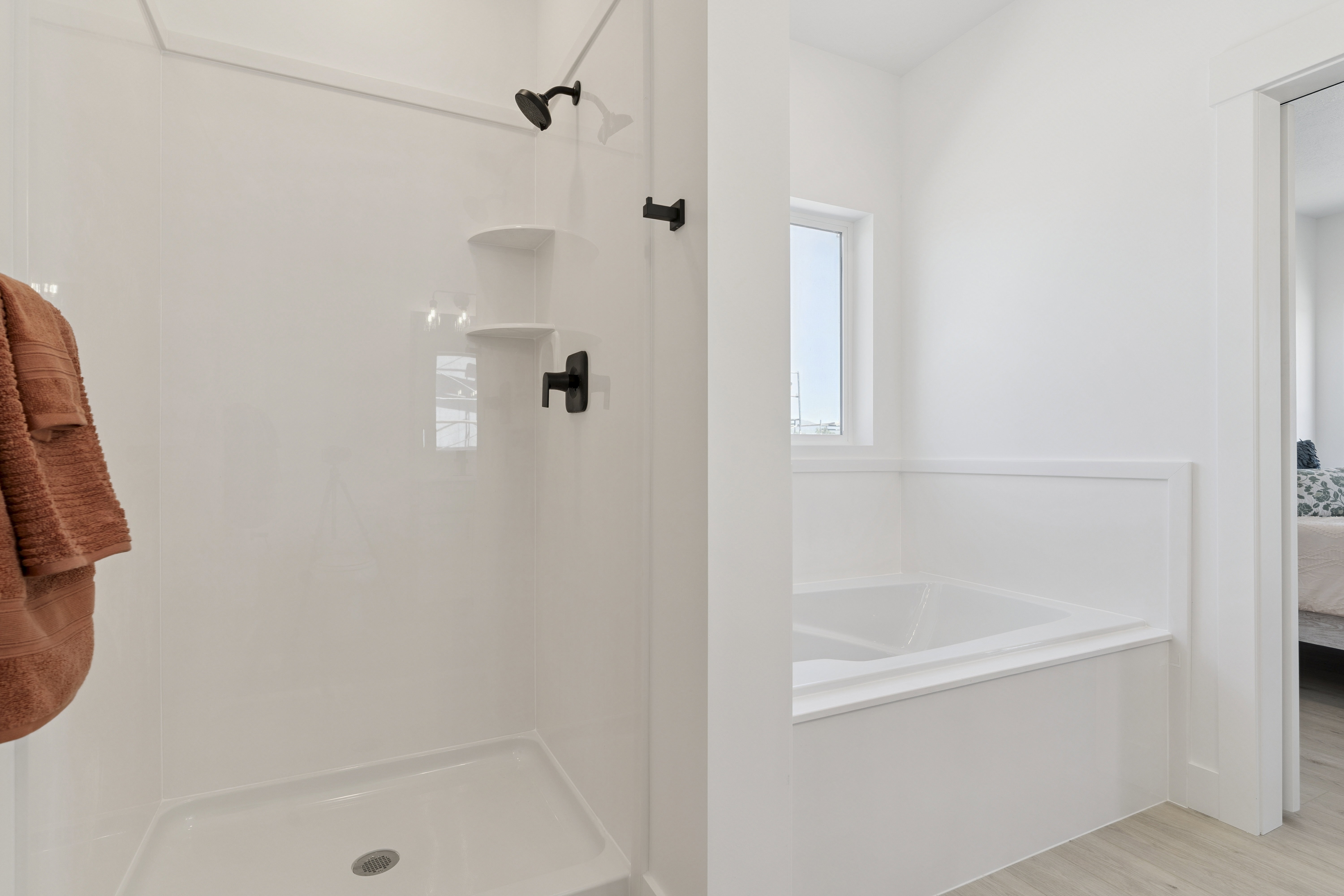 Bathroom featuring ensuite bath, a stall shower, a garden tub, and light wood-style floors