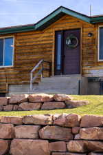Doorway to property featuring log siding