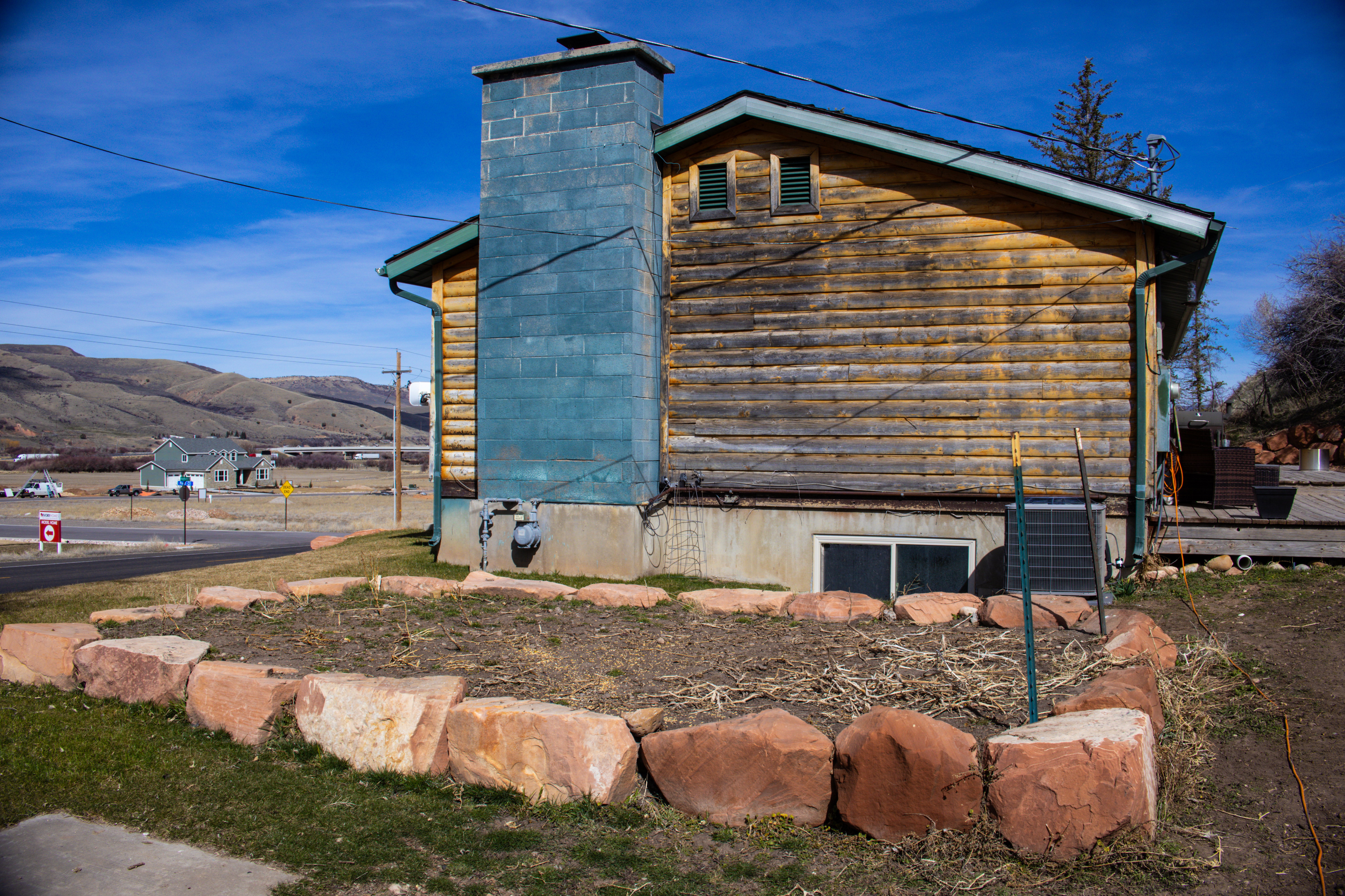View of side of property featuring a deck with mountain view and a cooling unit