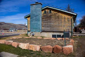View of side of property featuring a deck with mountain view and a cooling unit