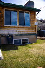 View of side of home featuring a yard and a chimney