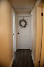 Hall with wood-style flooring and baseboards