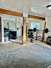 Workout area with carpet floors and a textured ceiling