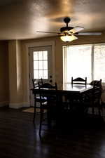 Dining area featuring wood-type flooring, a textured ceiling, and ceiling fan