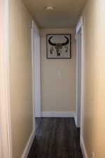 Corridor with wood finished floors and baseboards
