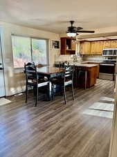 Dining area with a ceiling fan and dark wood finished floors