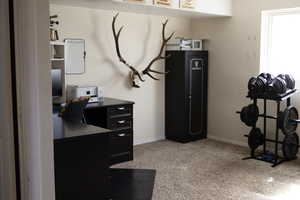 Home office with light carpet and baseboards