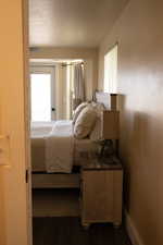 View of master bedroom from master bathroom featuring wood-type flooring and a textured ceiling