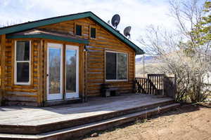 Back of property featuring a wooden deck and log exterior