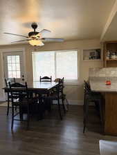 Dining room featuring wood-style floors, a textured ceiling, and a ceiling fan
