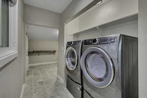 Laundry area featuring washer and dryer and light tile patterned floors
