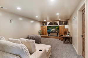 Carpeted home theater room featuring recessed lighting and baseboards