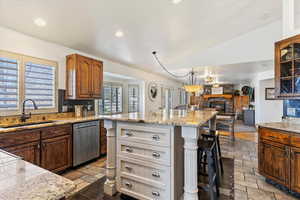 Two tone kitchen featuring dual tone cabinets, decorative backsplash, open floor plan, a kitchen breakfast bar, and dishwasher