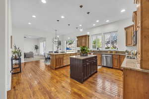 Kitchen featuring light stone countertops, hanging light fixtures, a peninsula, and light wood finished floors
