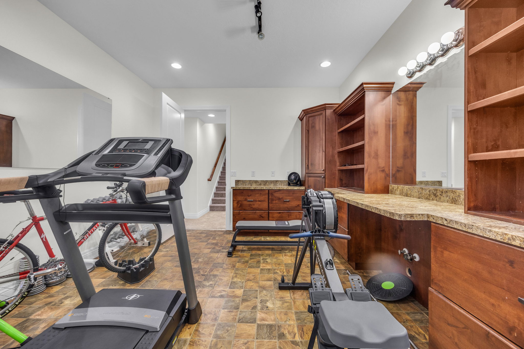 Workout room with stone finish flooring and recessed lighting